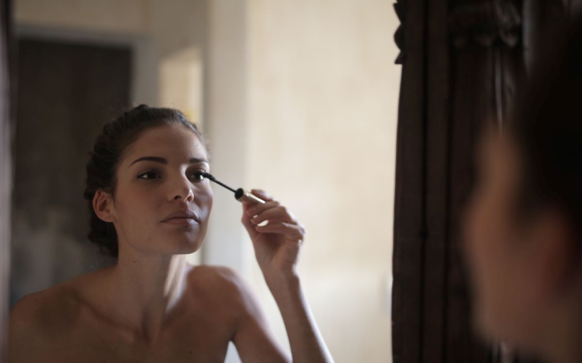 woman putting on mascara