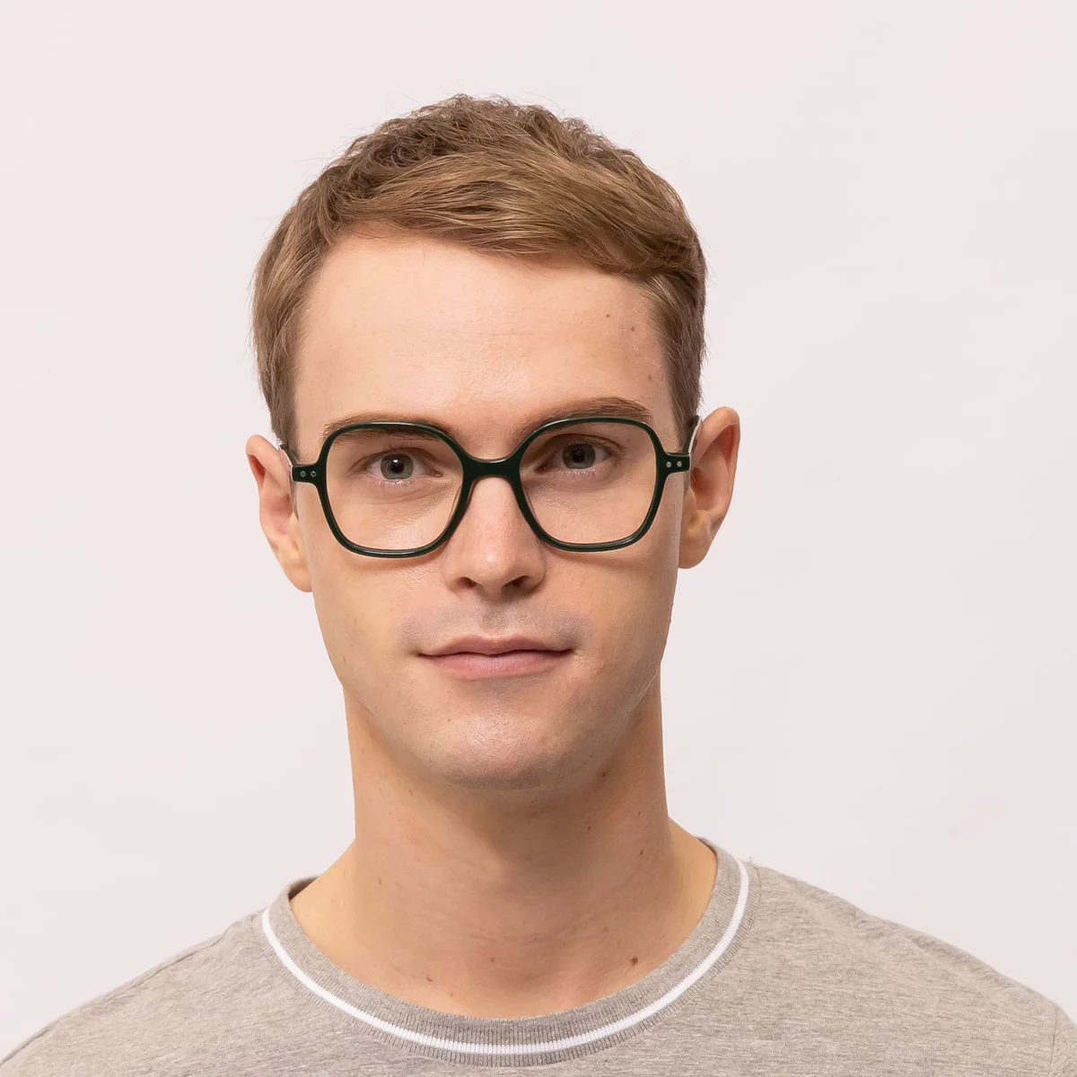 man wears oversized square glasses that makes his eyes appear bigger