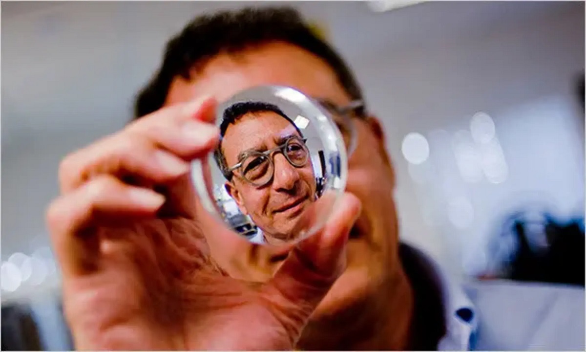 a man looking through a piece of lens