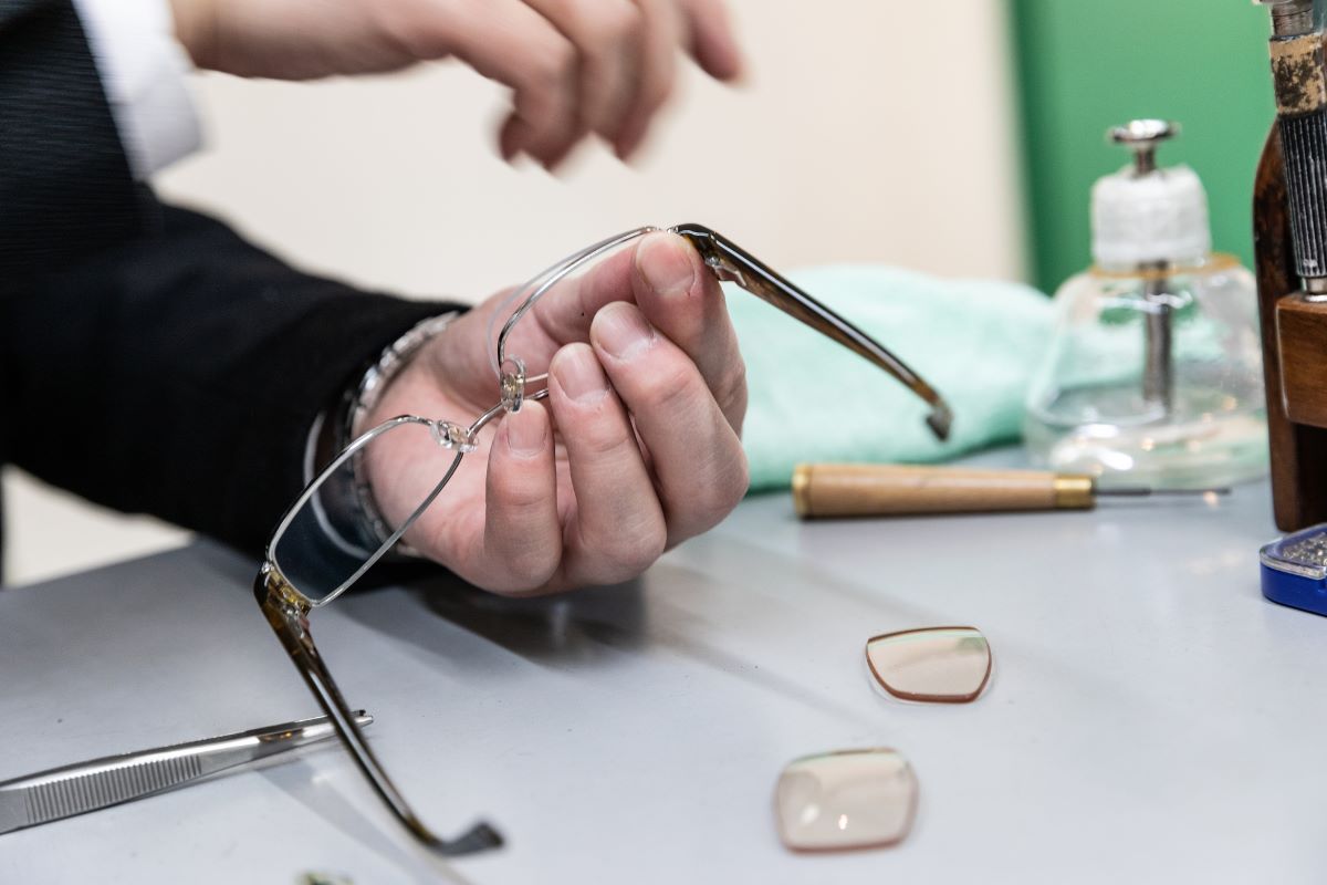 person holding eyeglasses by the lens