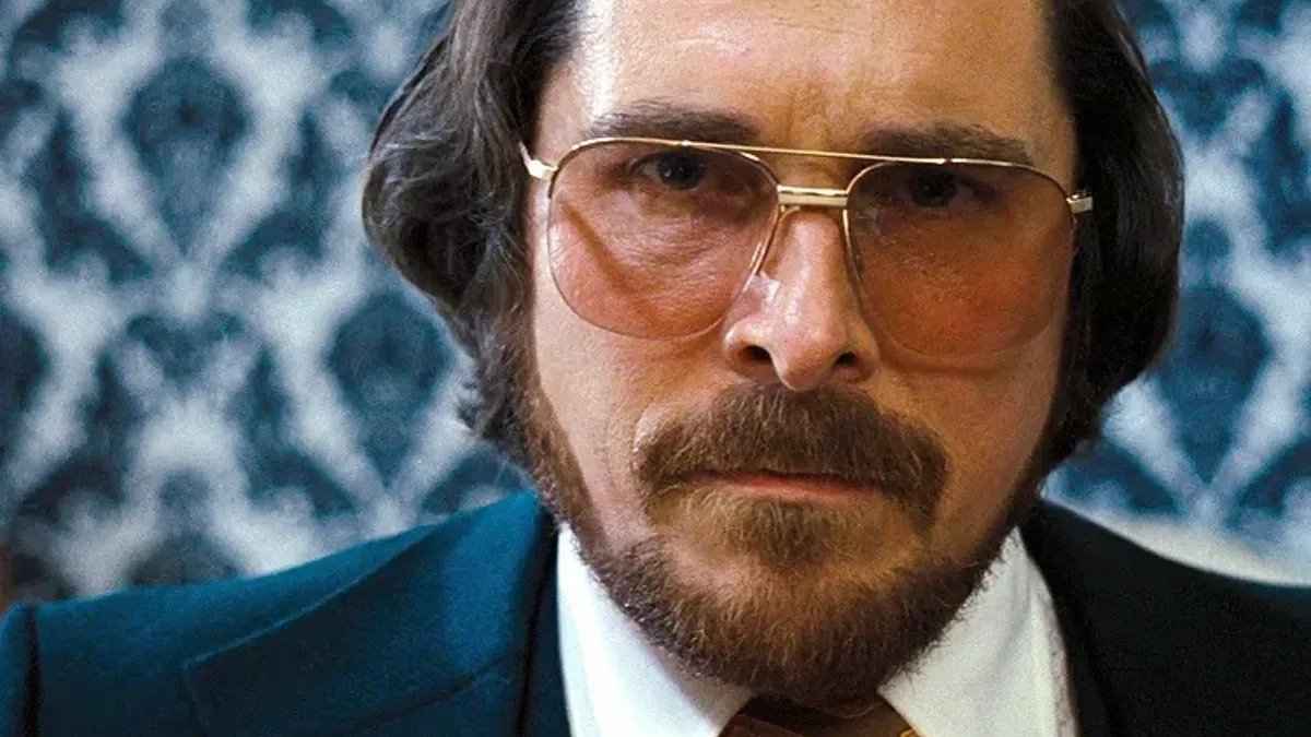 Christian Bales character wearing oversized double-bridged lightly tinted glasses in the movie American Hustle