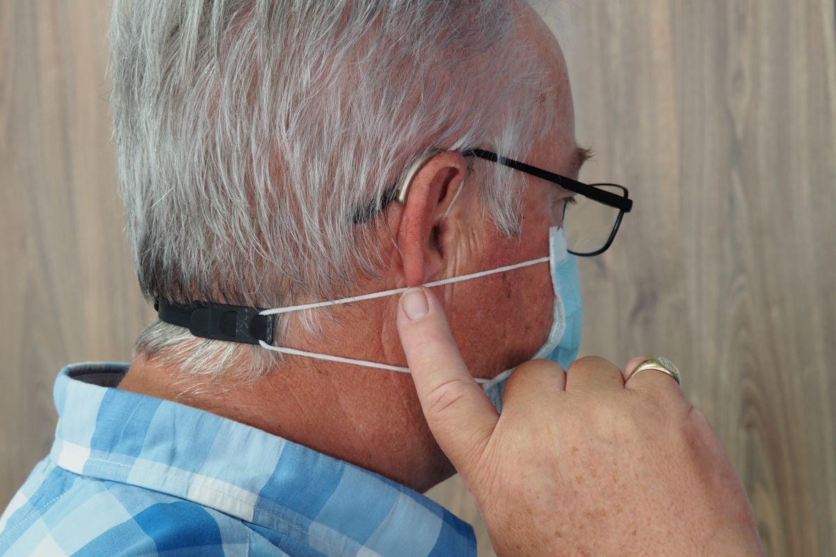 man wears glasses compatible with hearing aid 