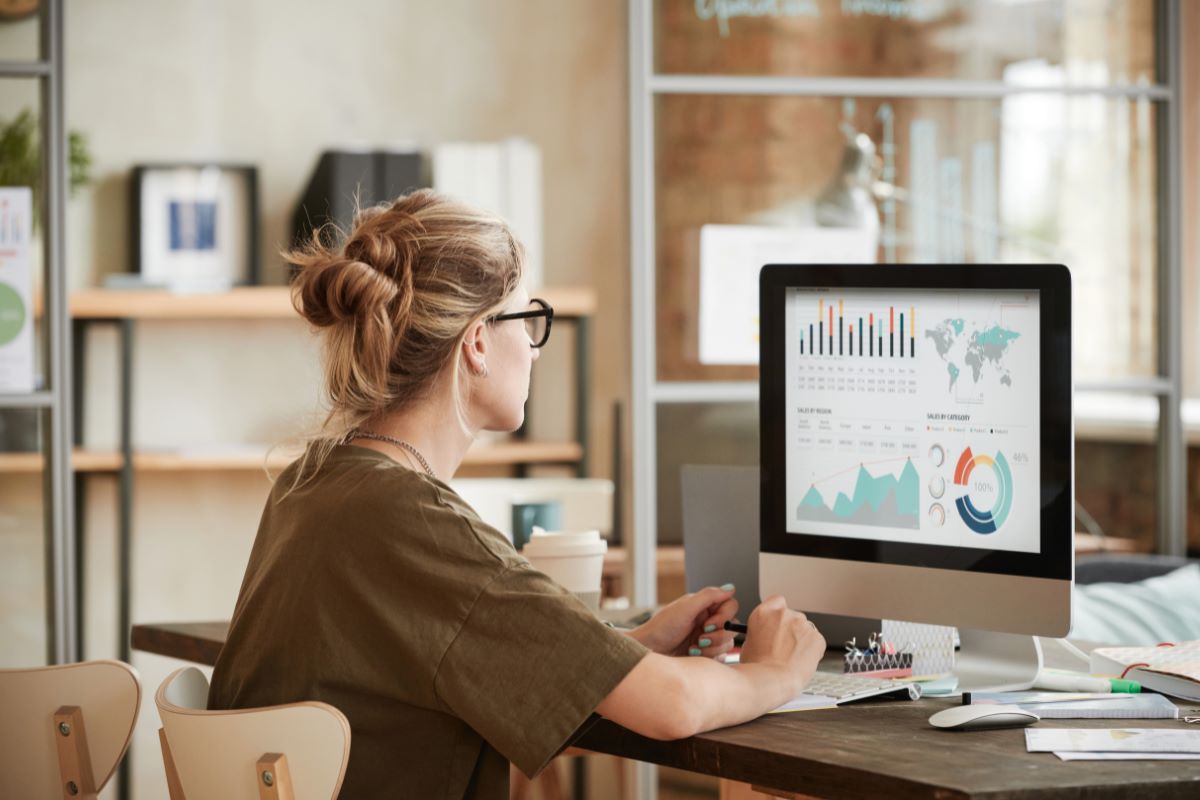 woman wearing eyeglasses in front of a computer screen