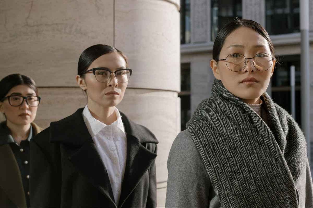 three asian woman wears thin black glasses frames in professional outfit