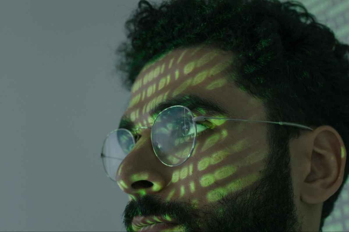 a man wears glasses staring into computer screen