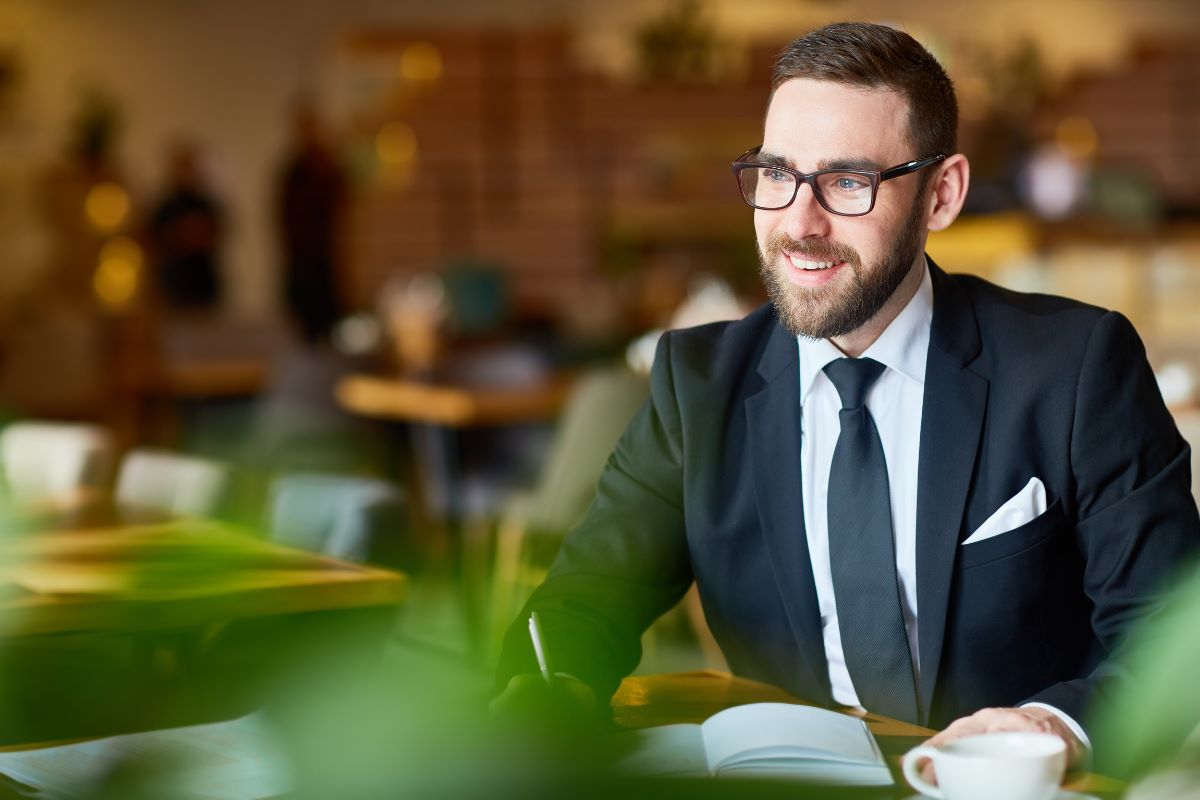 man wearing eyeglasses that match his suit