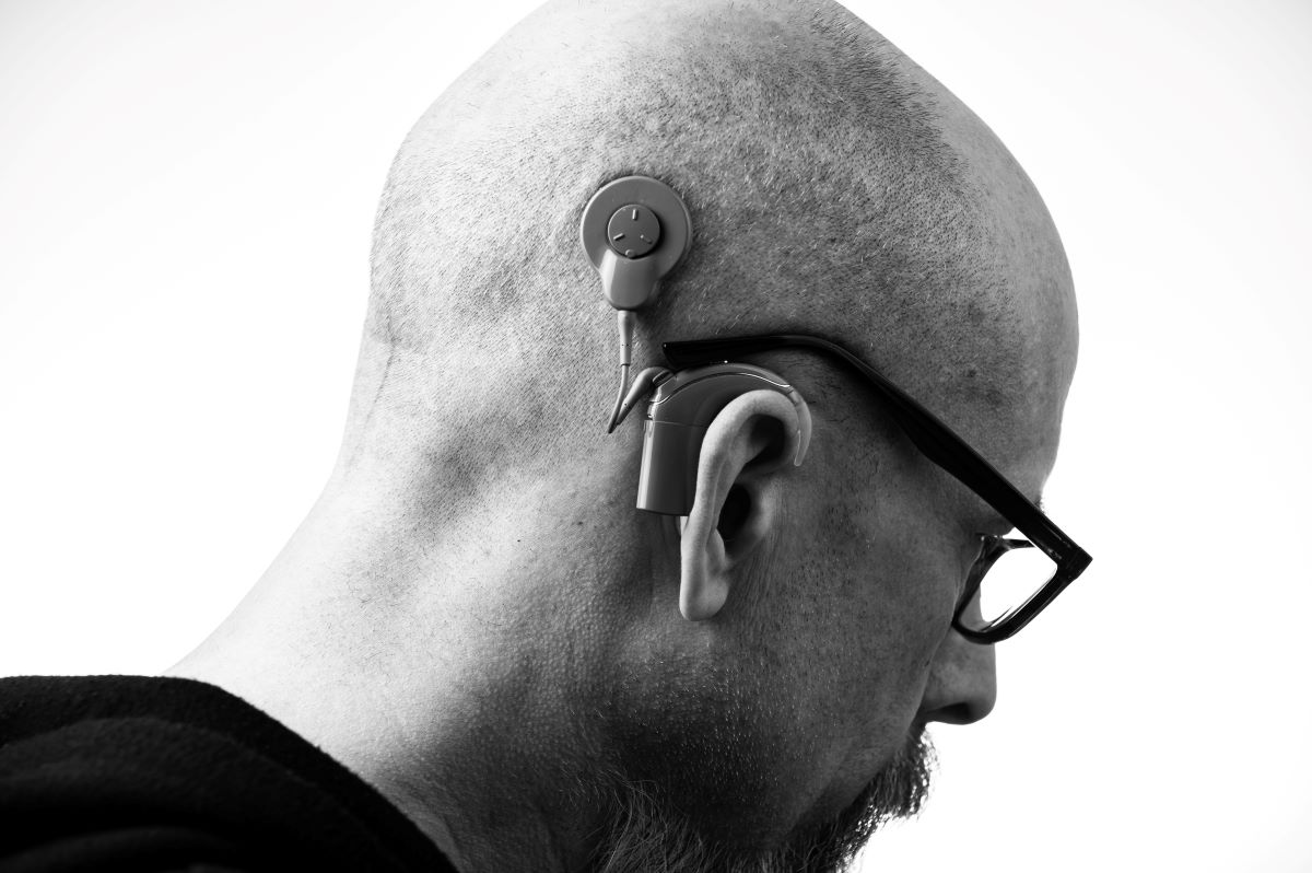 man wears glasses on top of hearing aids
