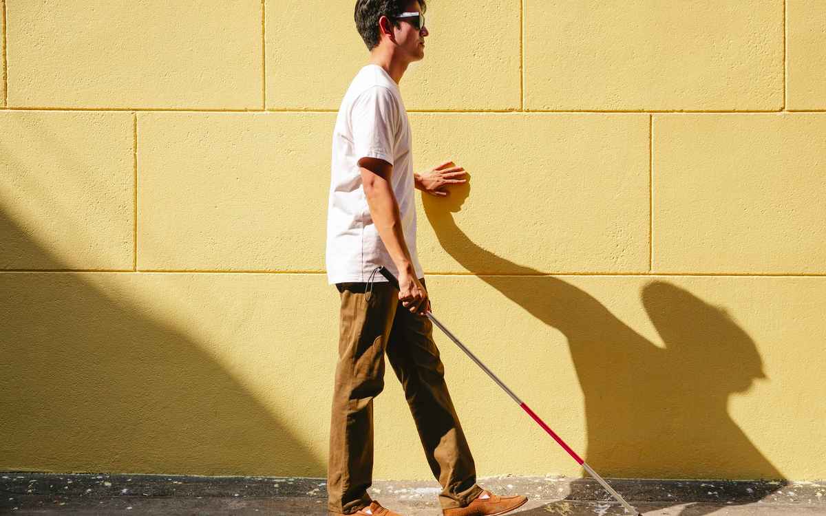 blind person walking with a cane 