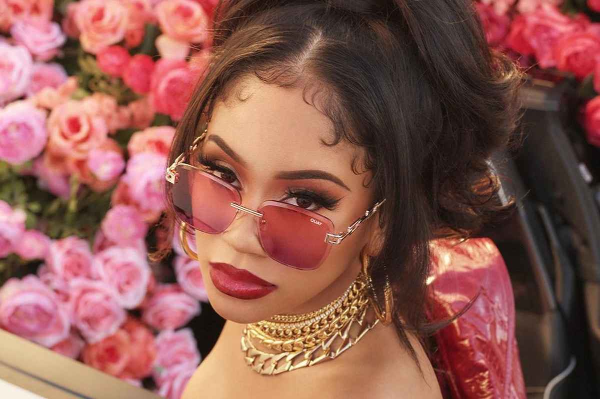 Saweetie wearing red gradient glasses that match her bold red lips