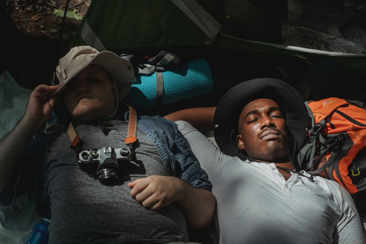 two man sleeping in an outdoor camping setup