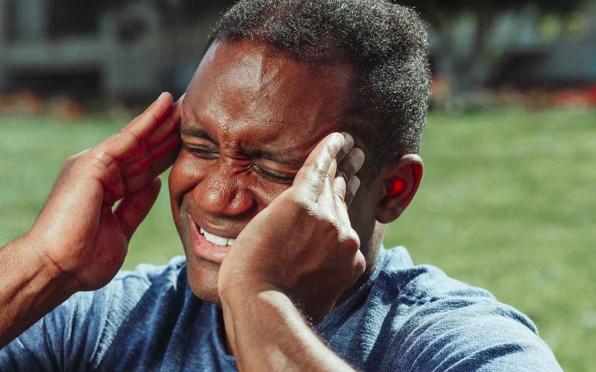 man experiencing headache due to exposing eyes to the sun
