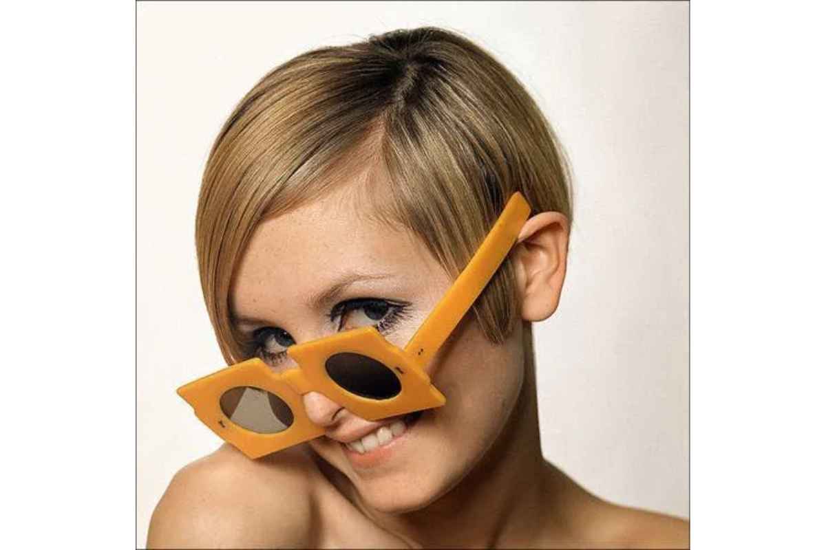 Twiggy wearing quirky cheese-like oversized square glasses with round lenses