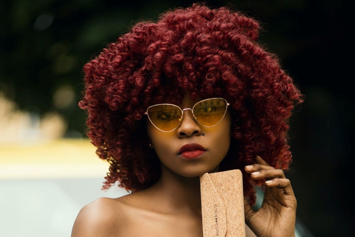 woman with afro wears cat eyeglasses to complement her almond eyes