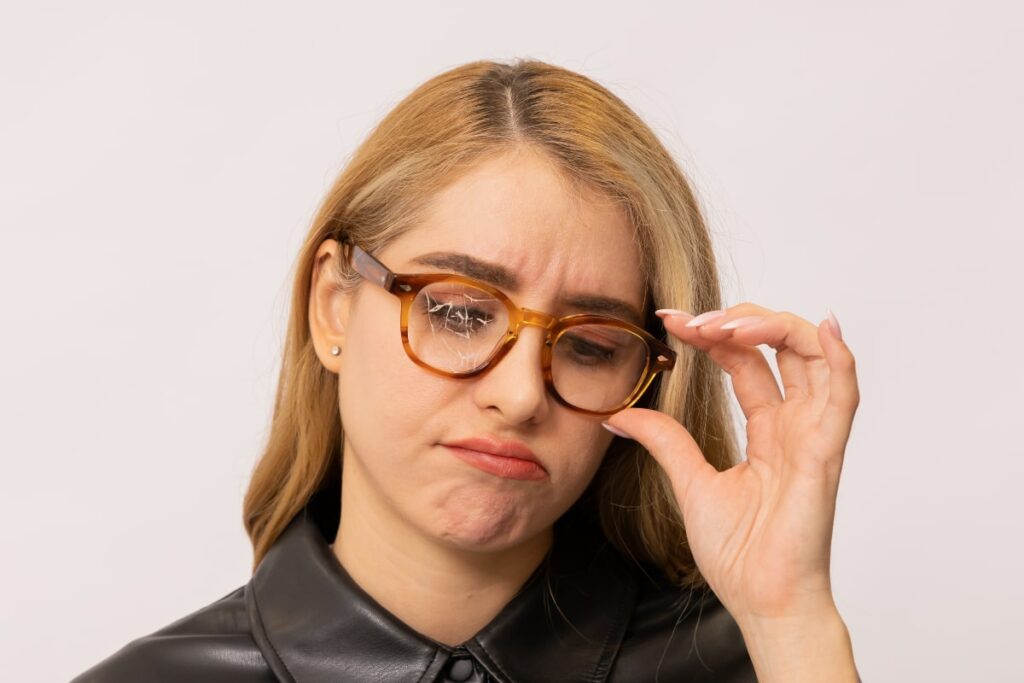 woman wears eyeglasses with one lens cracked