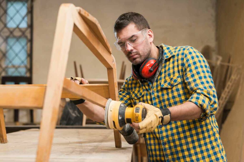 man wears safety glasses while doing carpentry