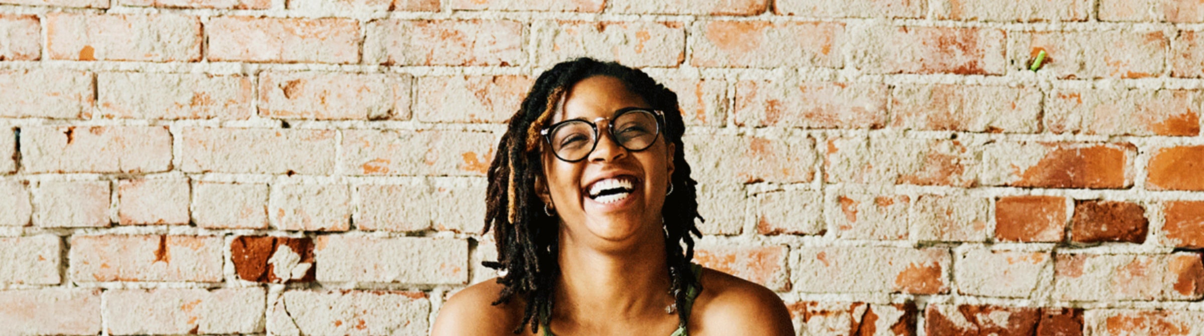 yoga teacher wears round glasses with a big smile