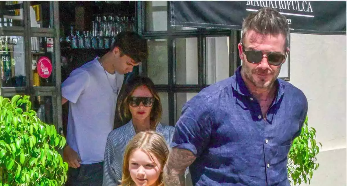 David Beckham wears aviator sunglasses and a blue cotton shirt