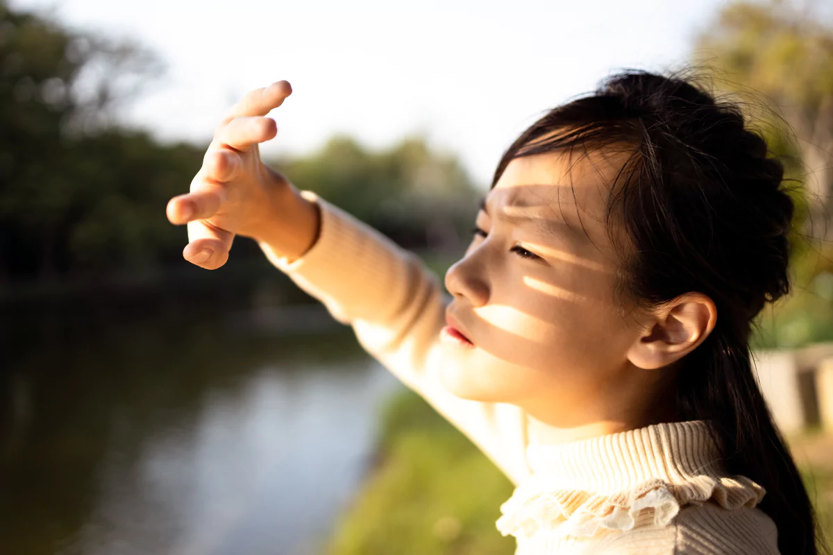 girl shielding eyes from sunlight