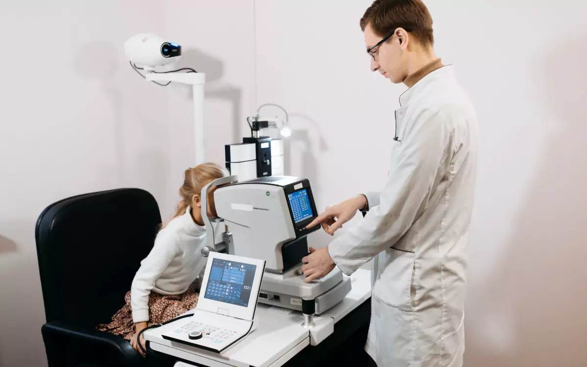 pediatric ophthalmologist using an autorefraction machine to test patient vision