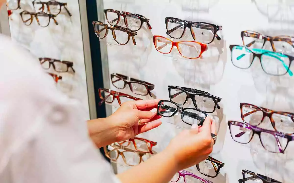 array of horn-rimmed glasses made of plastic on display rack