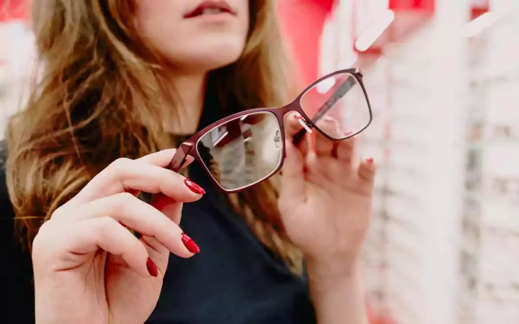 person holding glasses by the frames using both hands