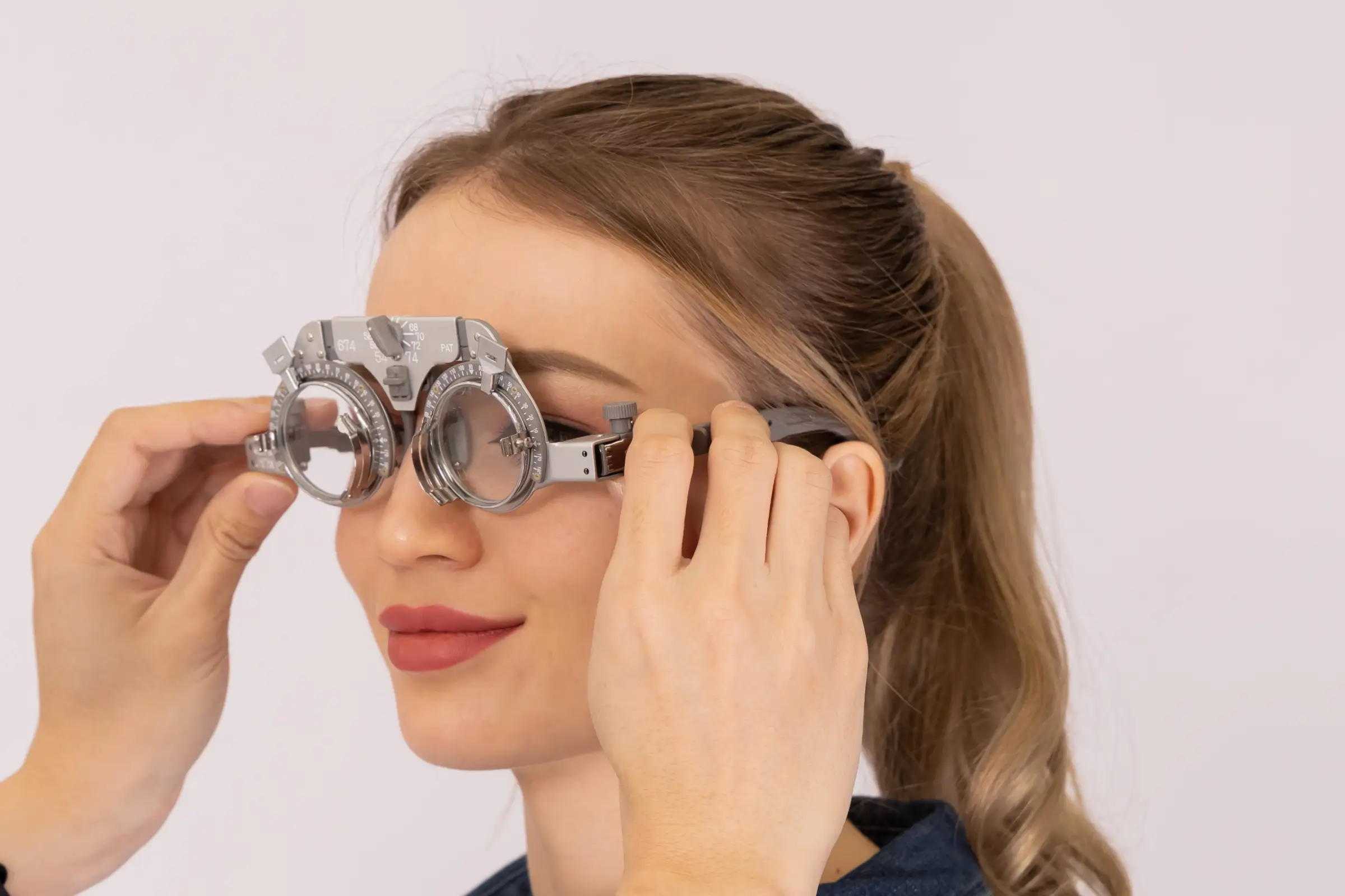 woman putting on trial frame for eye exam